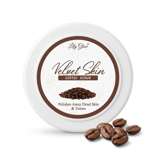 Round white container of Lily Glow Velvet Skin Coffee Scrub featuring a brown label design, a small pile of coffee beans, and loose coffee beans resting on a white surface.